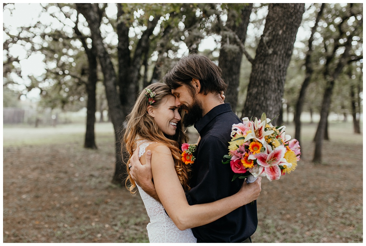 bride and groom laughing with wild flowers