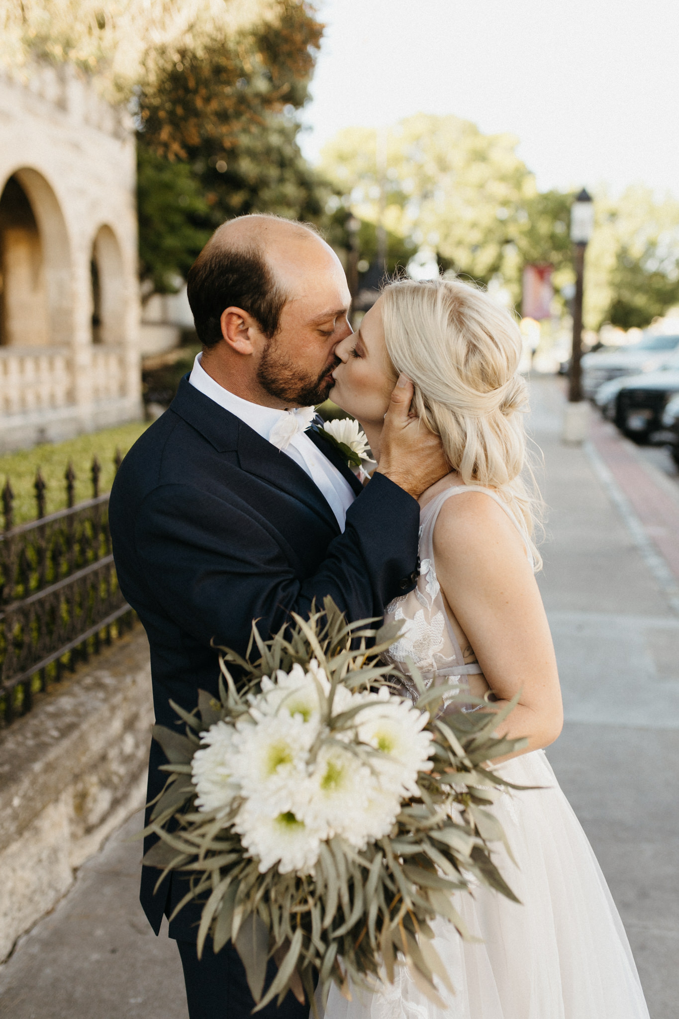 bride and groom kissing in front of mansion kerrville photographer leah thomason