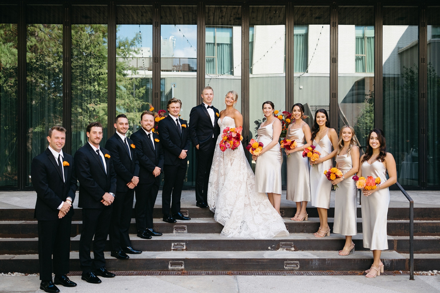A wedding party standing on stairs in a hotel courtyard